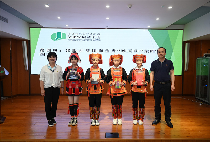 廣西師范大學(xué)出版社集團(tuán)副總裁、工會(huì)主席莫曲波（右一）代表出版社向金秀“獨(dú)秀班”同學(xué)贈(zèng)送圖書（李顯楊攝）.jpg