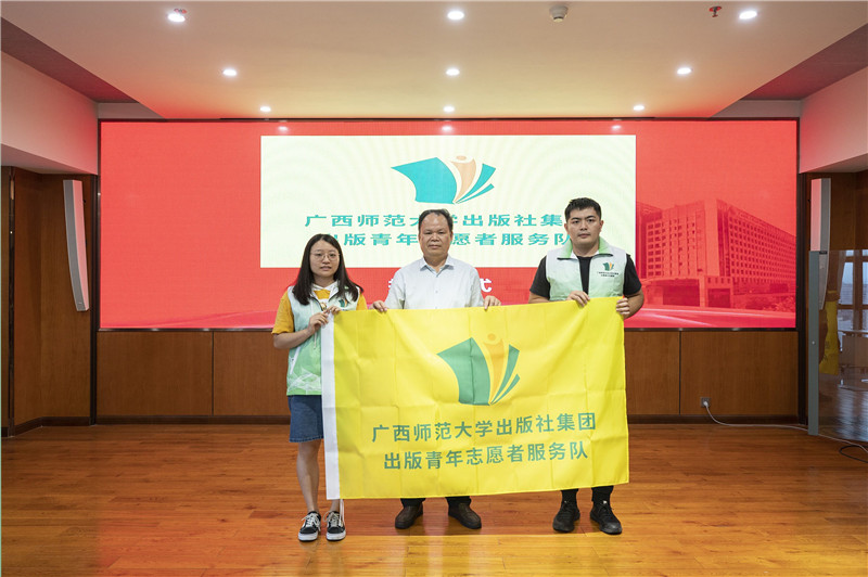 2.董事長為出版青年志愿者服務(wù)隊授旗.jpg